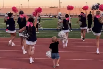 WATCH: 2-Year-Old Joins Big Sister's Cheerleading Routine 📣 - NowThis