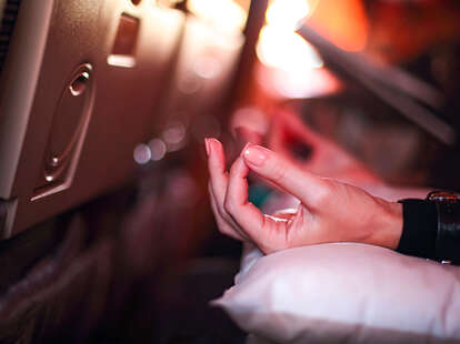 woman meditating in airplane seat