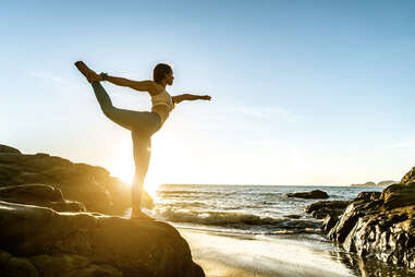 Woman doing yoga on the beach