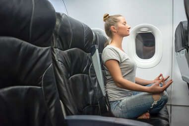 person doing yoga in airplane seat