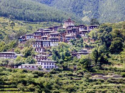 buildings tucked into mountain forest