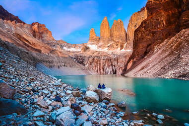 people looking at rock formations and lake