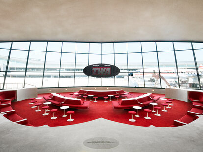 The Sunken Lounge at the TWA Hotel features a split-flap exit panel by Solari di Udine and a view of the Lockheed constellation 