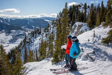 two skiers admiring mountaintop view at crested butte mountain resort