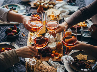 clinking of orange wine glasses at holiday dinner party 
