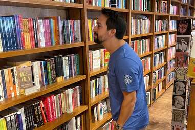 Man Looking at Shelves of Books & Books