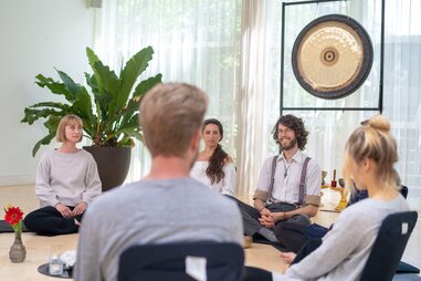 people sitting on floor beside giant gong