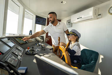 child driving boat with captain