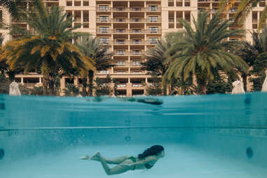 photo of woman swimming in hotel pool