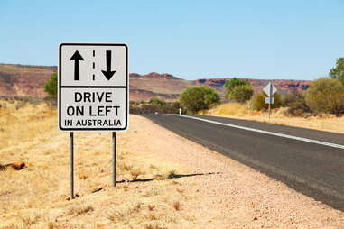 Sign that says “Drive on the left in Australia” on side of road