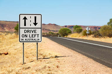 Sign that says "Drive on the left in Australia" on side of road