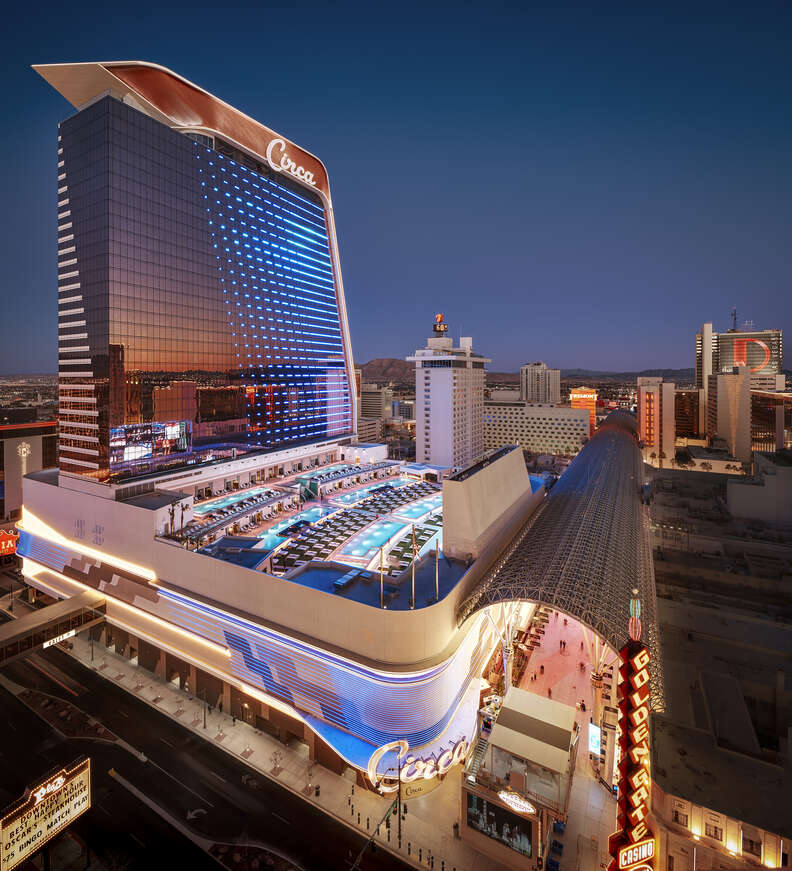 a tall shiny hotel with an outdoor pool setup