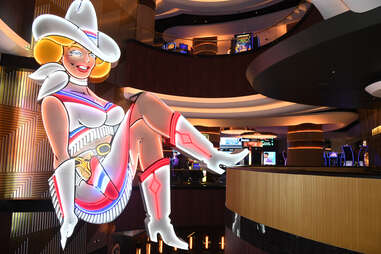 a neon sign of a cowgirl kicking up her leg