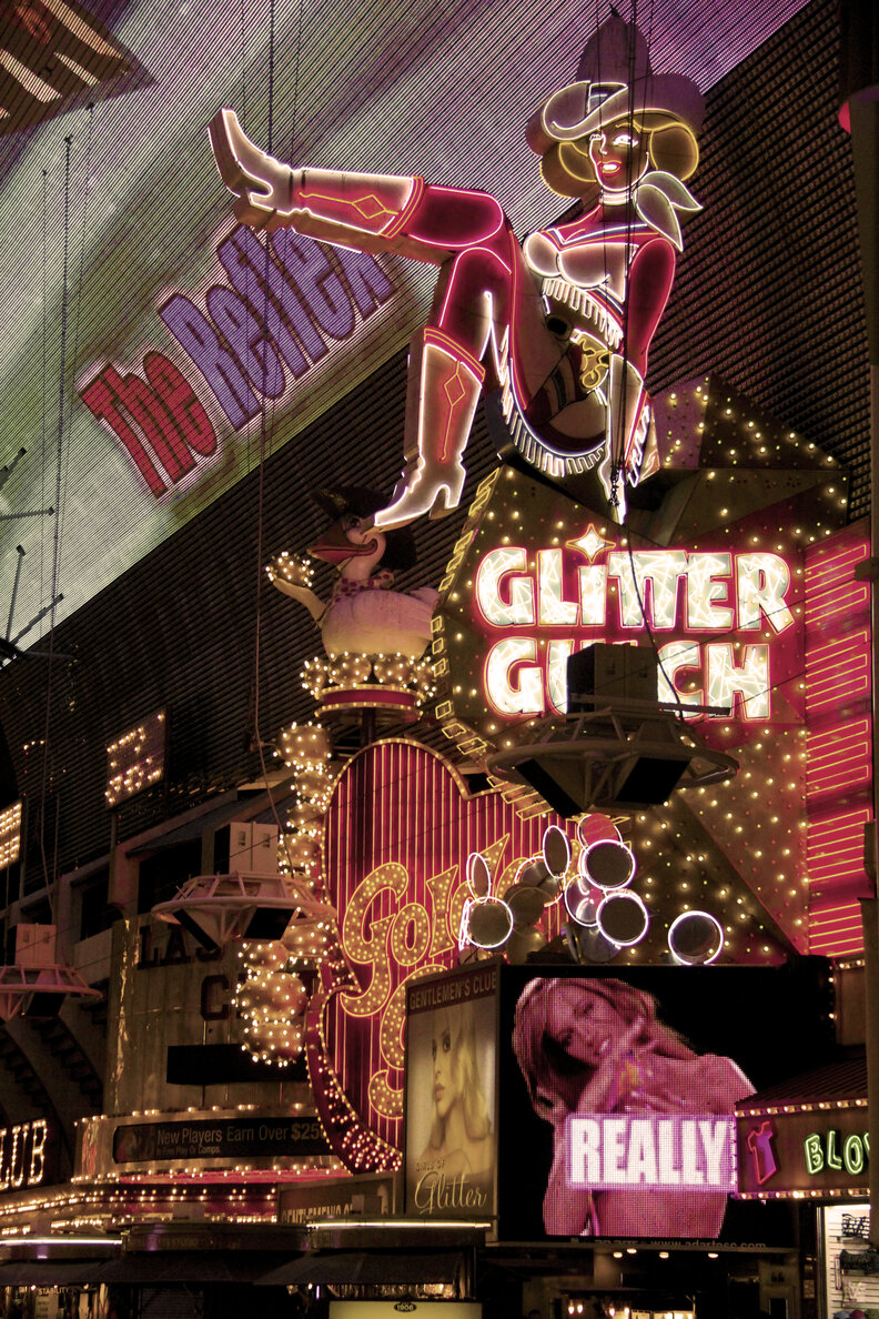 a vintage photo of downtown las vegas with neon signs