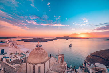 Amazing evening view of Fira, caldera, volcano of Santorini, Greece with cruise ships at sunset. 