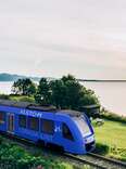 The Train de Charlevoix, North America's first zero-emission train, travels along a railroad track on a sunny day