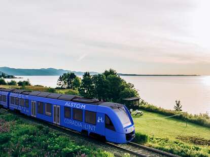 The Train de Charlevoix, North America's first zero-emission train, travels along a railroad track on a sunny day