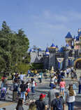 Visitors to Disneyland in front of Sleeping Beauty's castle in Anaheim, California