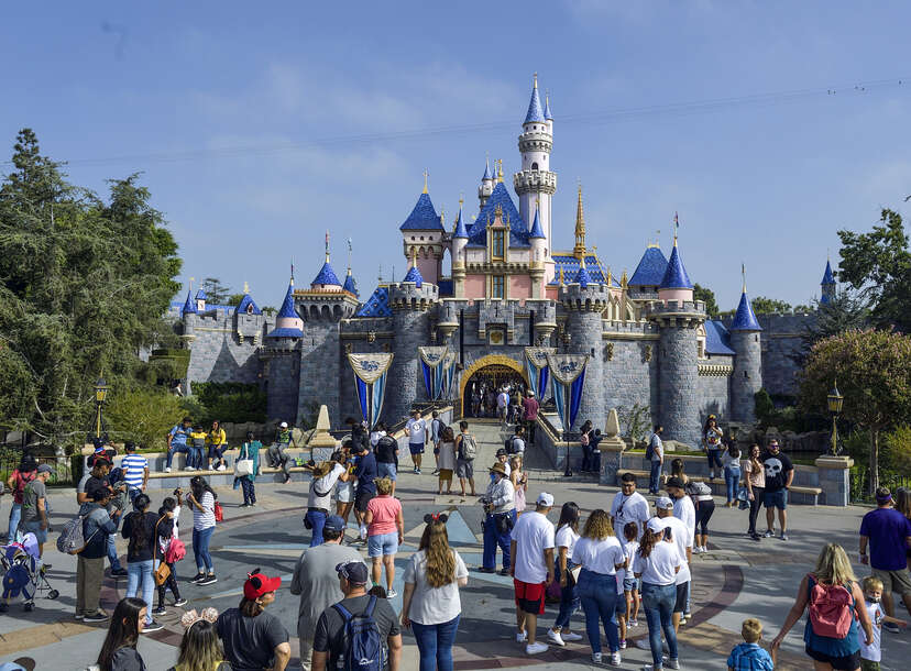 Visitors to Disneyland in front of Sleeping Beauty's castle in Anaheim, California