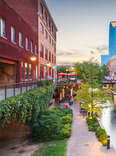 Oklahoma City's Bricktown at Dusk. Sidewalk next to small waterway and lots of colorful lighting. 