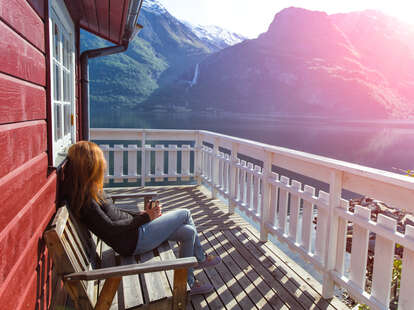 Woman sitting on deck of lake house