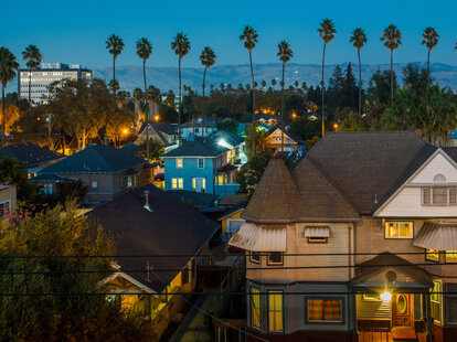 Houses and palm trees pictured near San Jose&rsquo;s downtown district at dusk