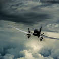 A plane flying into a dark and stormy sky. 