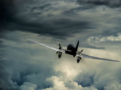 A plane flying into a dark and stormy sky. 