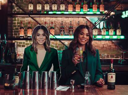 Regina Hall and her Jameson Desk Double at a bar drinking a glass of whiskey.
