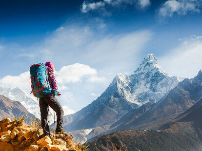 A woman trekking with a backpack on in the Himalayan Mountains.