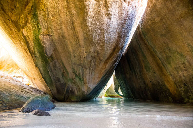 Rocks that lean against each other with sunlight streaming through