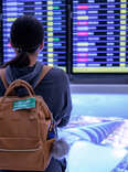 Young woman at an airport is checking for the flight schedule