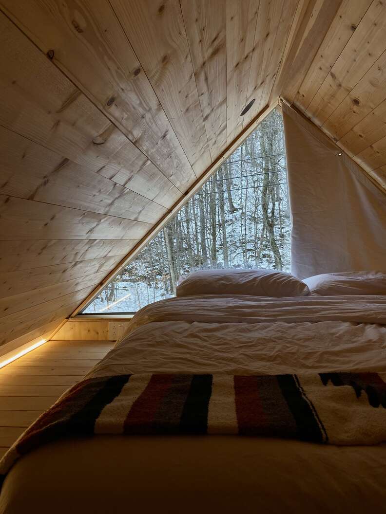 The view of a bed inside a cabin at the Eastwind Oliverea Valley Hotel in the Catskills