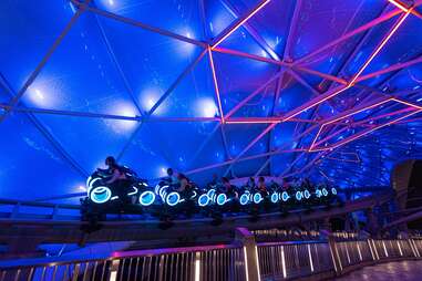 Riders on the TRON/Lightcycle Run roller coaster at Disney World