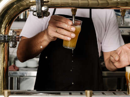 A bartender pours beer out of a keg at a bar