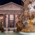 A view of the Pantheon in Rome at night, with a fountain in the foreground. 