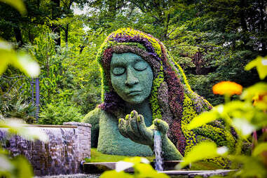 Earth Goddess plant sculpture among greenery at Atlantic Botanical Garden