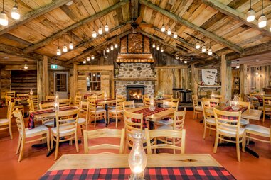 interior of Sucrerie de la montagne with tables and a roaring fire