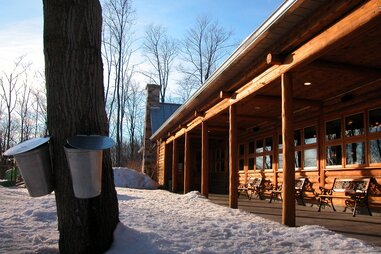 pails collecting maple sap outside of Auberge des Gallant hotel