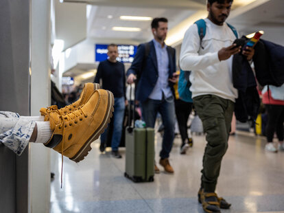 A passenger rests at the airport while waiting for his delayed flight to Las Vegas