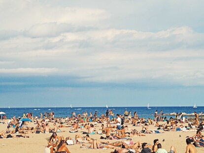 A crowded beach in Barcelona, Spain during the summer.