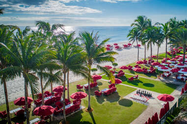 red umbrellas by the beach at Acqualina Resort & Residences