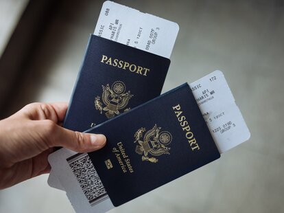 Passports and flight tickets held in one hand.