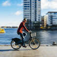 A young man at the Dublin, Ireland city dock riding a city bike