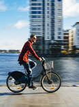 A young man at the Dublin, Ireland city dock riding a city bike