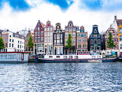 A view of the Amsterdam canals and colorful homes on a sunny day. 