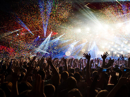 A crowd of people during a music festival at night.