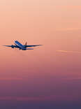plane taking off at sunset