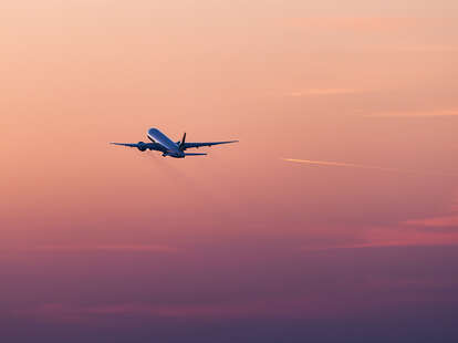 plane taking off at sunset
