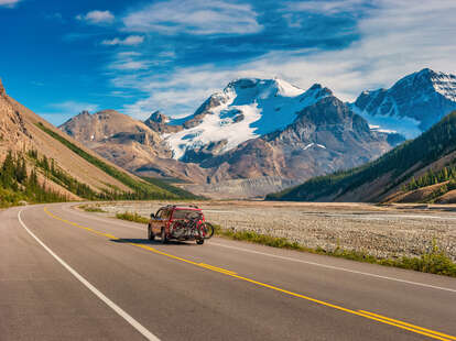 car driving along scenic icefields parkway in alberta, canada